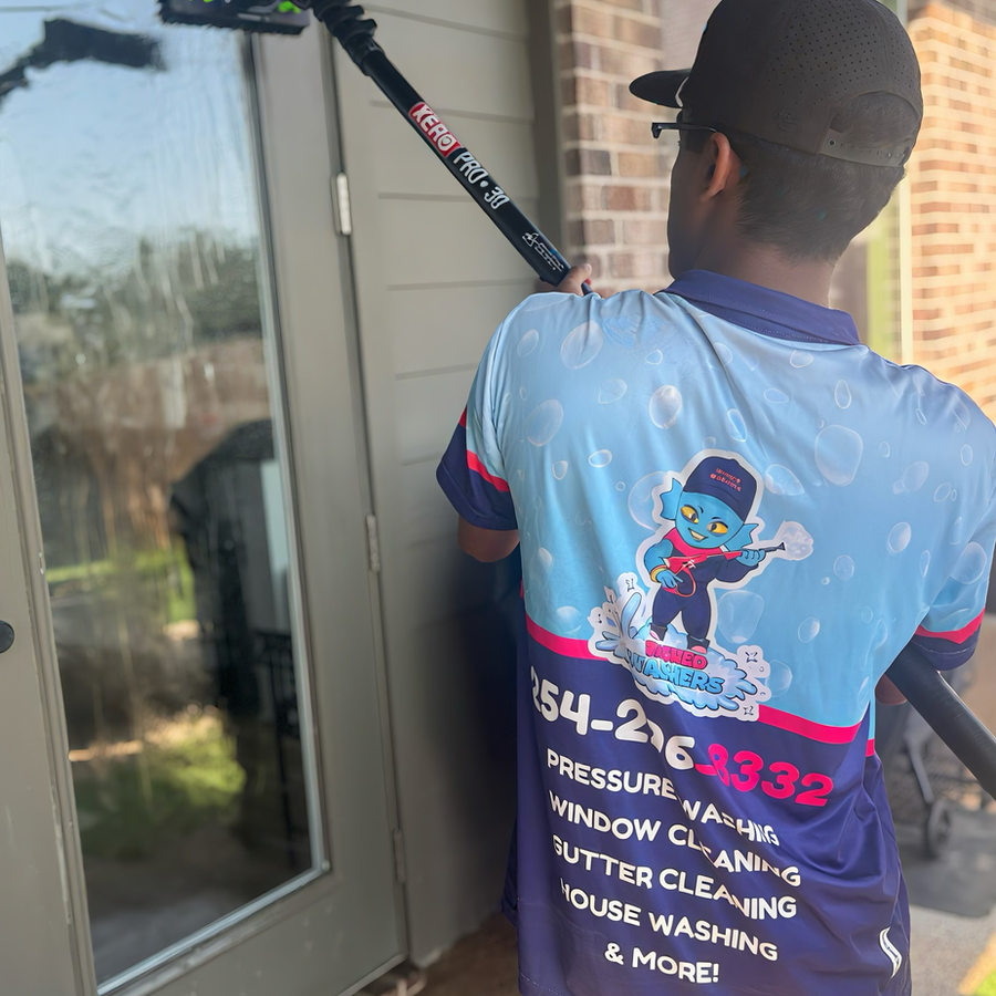 Window cleaning and soft wash technician with branded Wicked Washers shirt in Waco TX